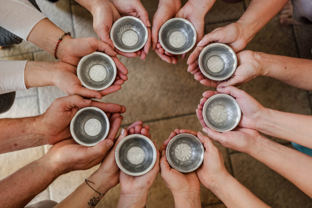 Hier halten alle TeilnehmerInnen von Sonja Blessings Weiterbildung zur Lomi Lomi Massage ein Schälchen aus Porzellan in den Händen.