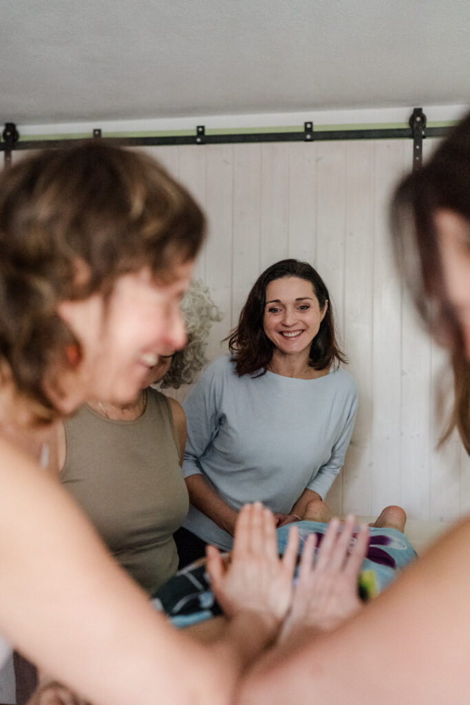 Teilnehmerinnen der Ausbildung zur Lomi Lomi Massage bei Sonja Blessing und ihre, Team sind hier voller Leidenschaft bei einer Massage zu sehen.